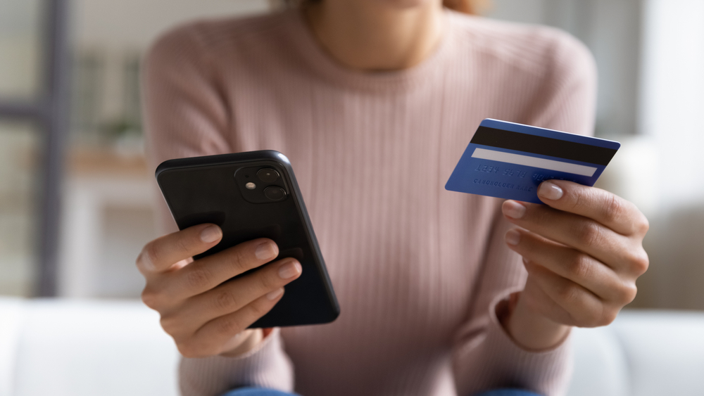 woman holding mobile phone and credit card